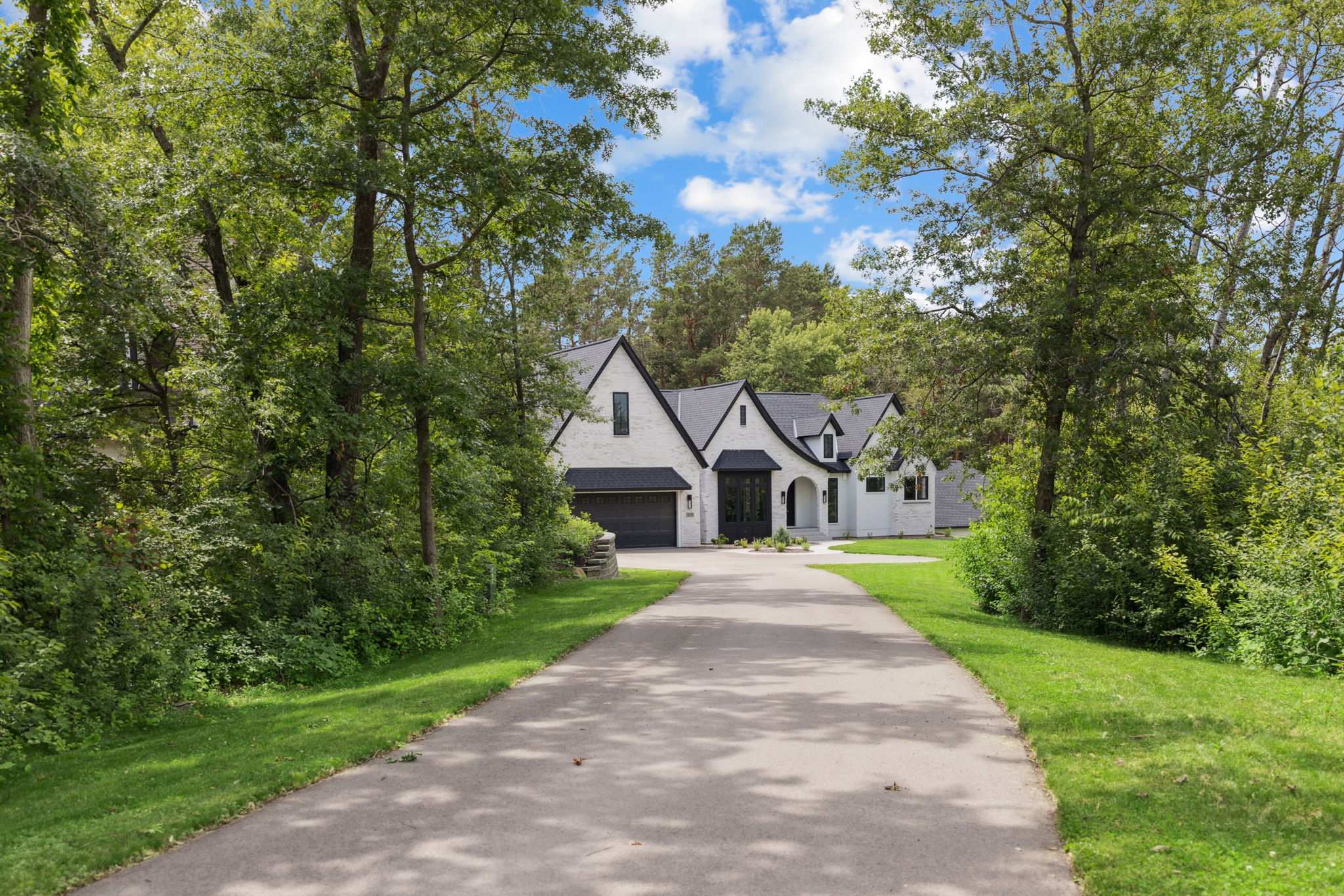 Driveway approach to the home through mature trees