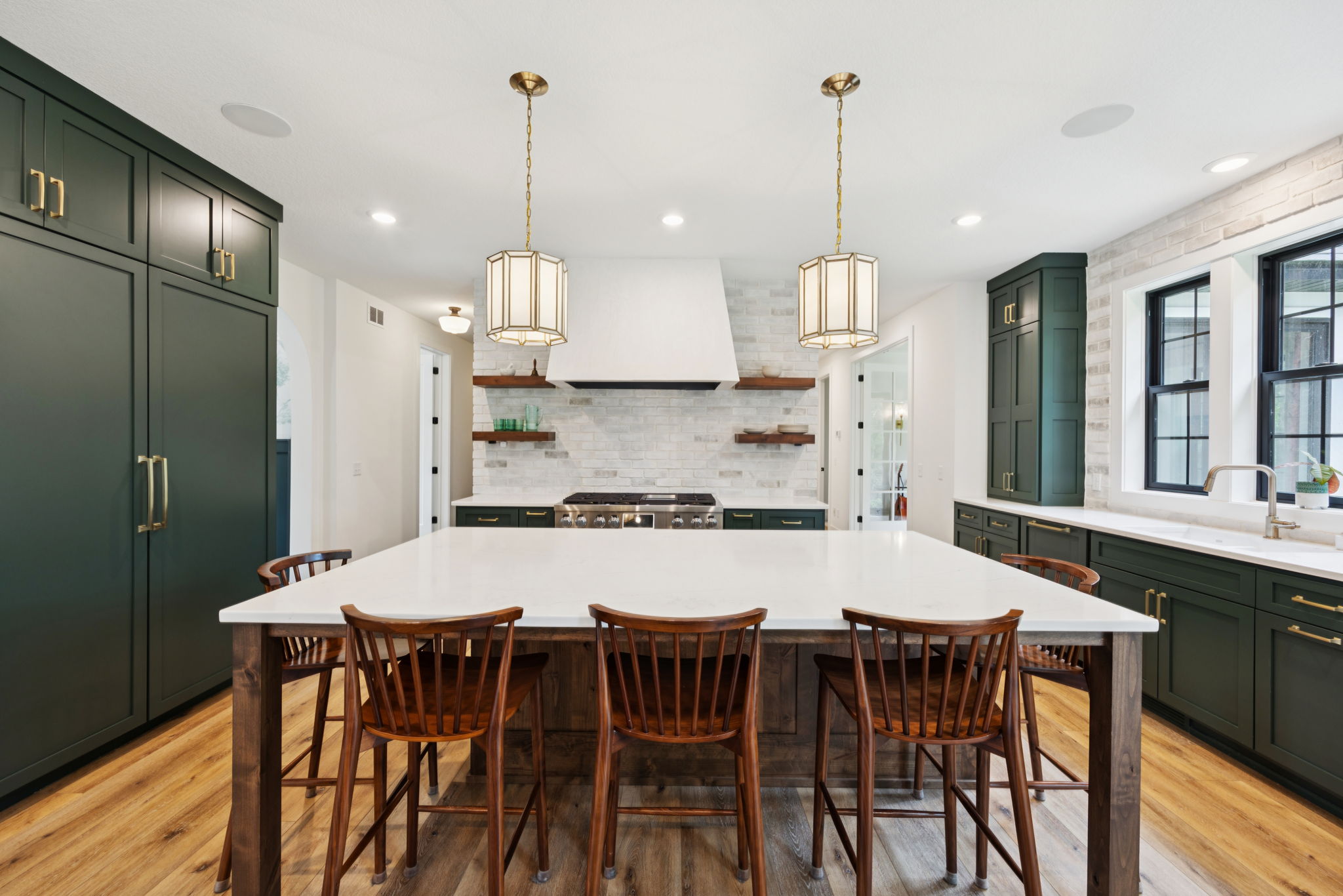 Kitchen with forest-green cabinetry and large island seating six